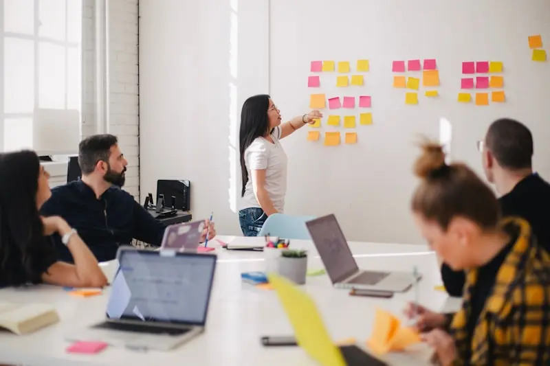 Équipe PME autour d'une table avec ordinateur portable — réunion de pilotage projet informatique