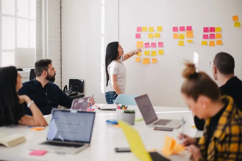 Équipe PME autour d'une table avec ordinateur portable — réunion de pilotage projet informatique
